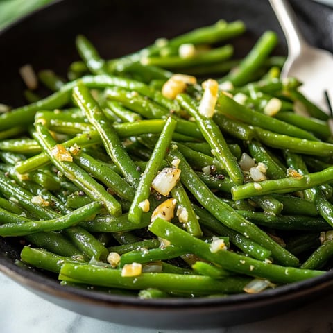 A bowl of sautéed green beans with garlic.