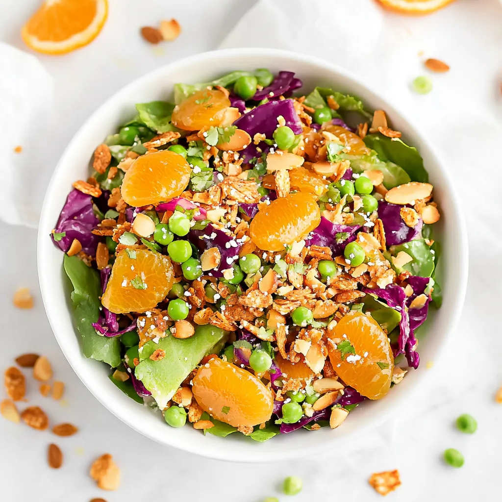 A bowl of salad with peas, oranges, and almonds.