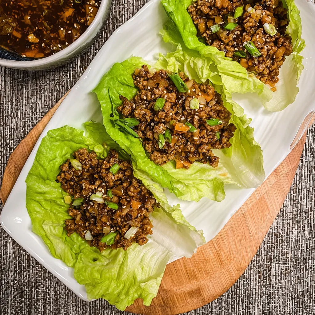 Two pieces of meat with lettuce on a plate.