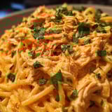 A dish of pasta with chicken and cheese.