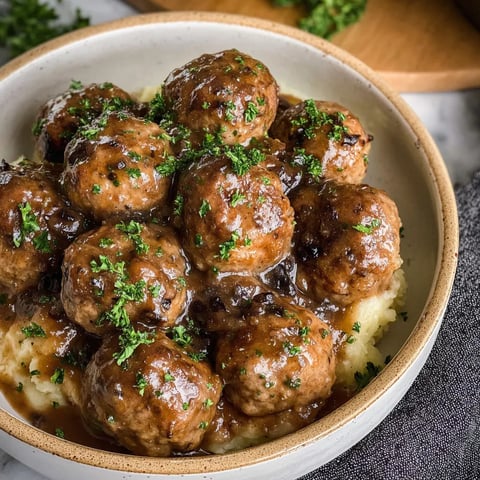 A bowl of meatballs with gravy.