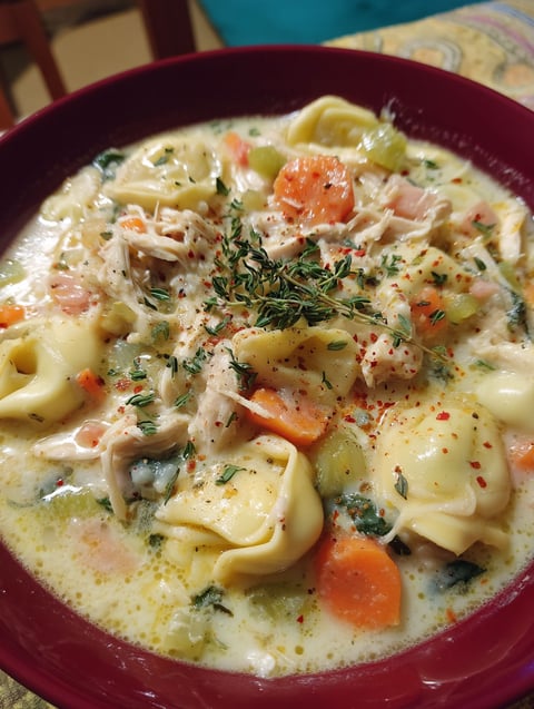 A bowl of creamy chicken tortellini soup.