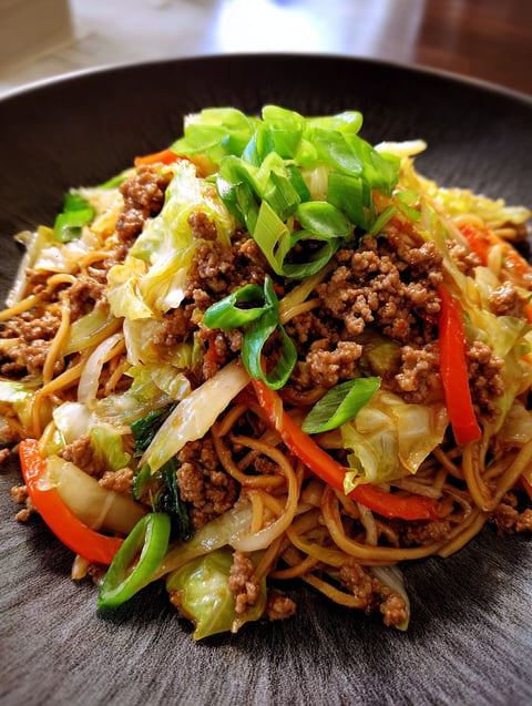 A plate of food with a stir fry of ground beef and cabbage.