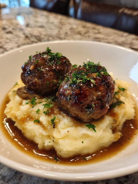 A plate of meatballs and mashed potatoes.